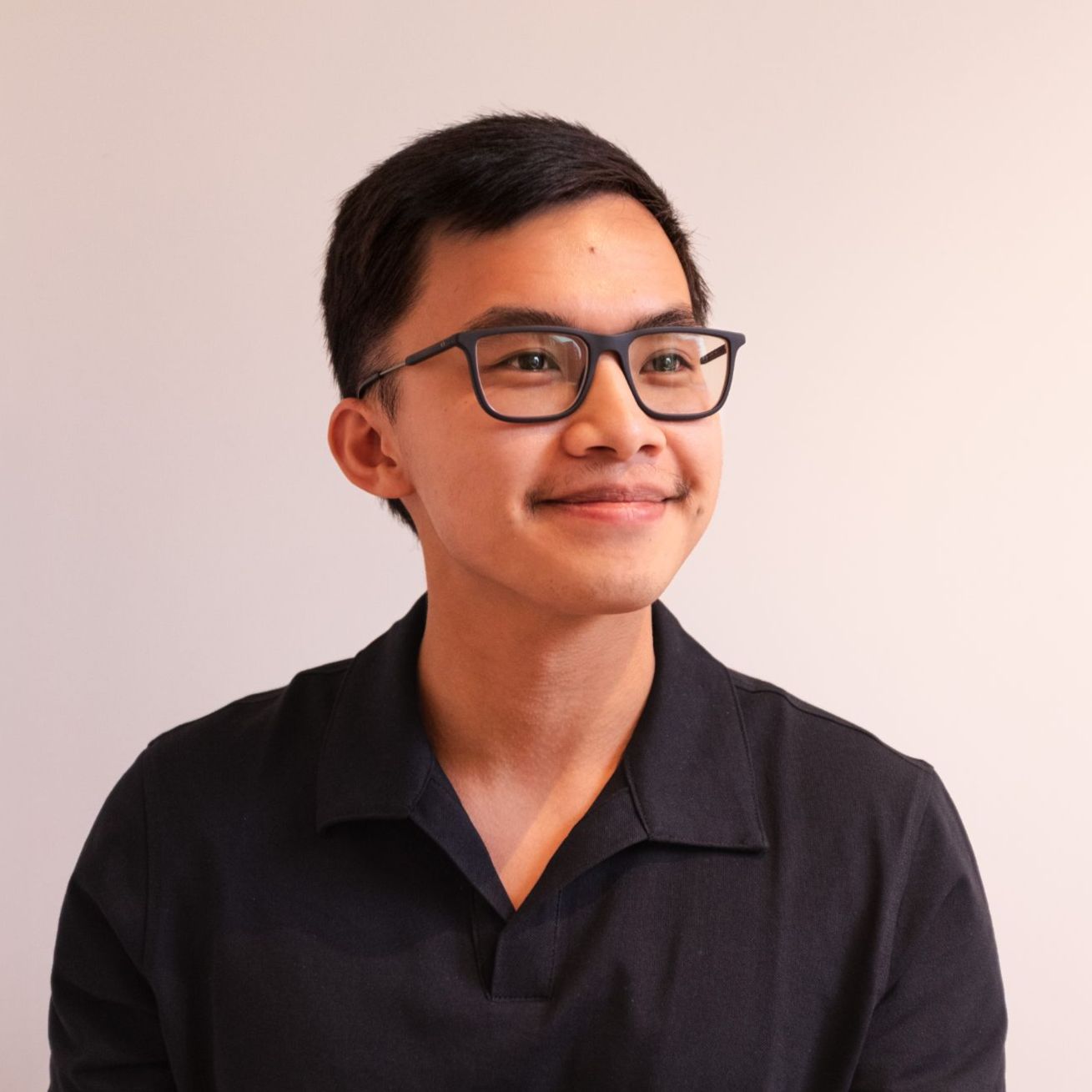 Christopher Nguyen Portrett av ung mann med briller og mørkt hår, ikledd sort kortarmet skjorte